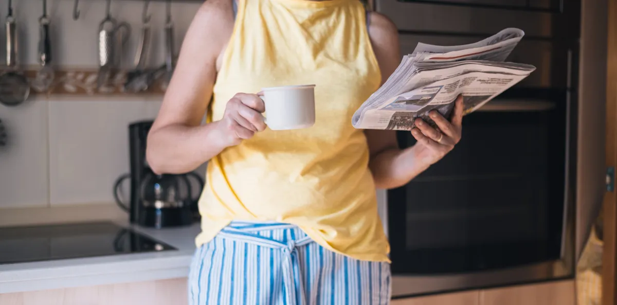 Reggel kávézó és újságot olvasó ember pizsamában a személyiségtesztben.