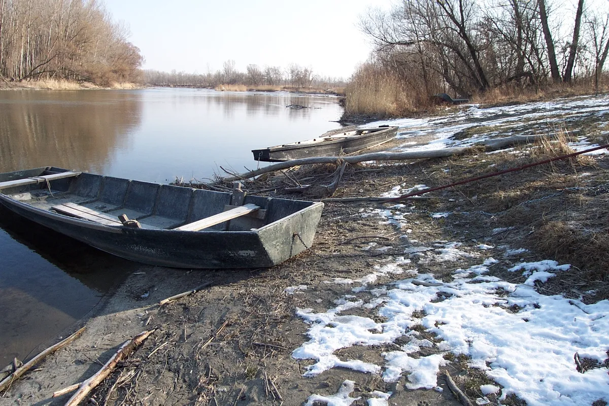 Téli táj a Szigetközben partra húzott csónakokkal, folyóval.