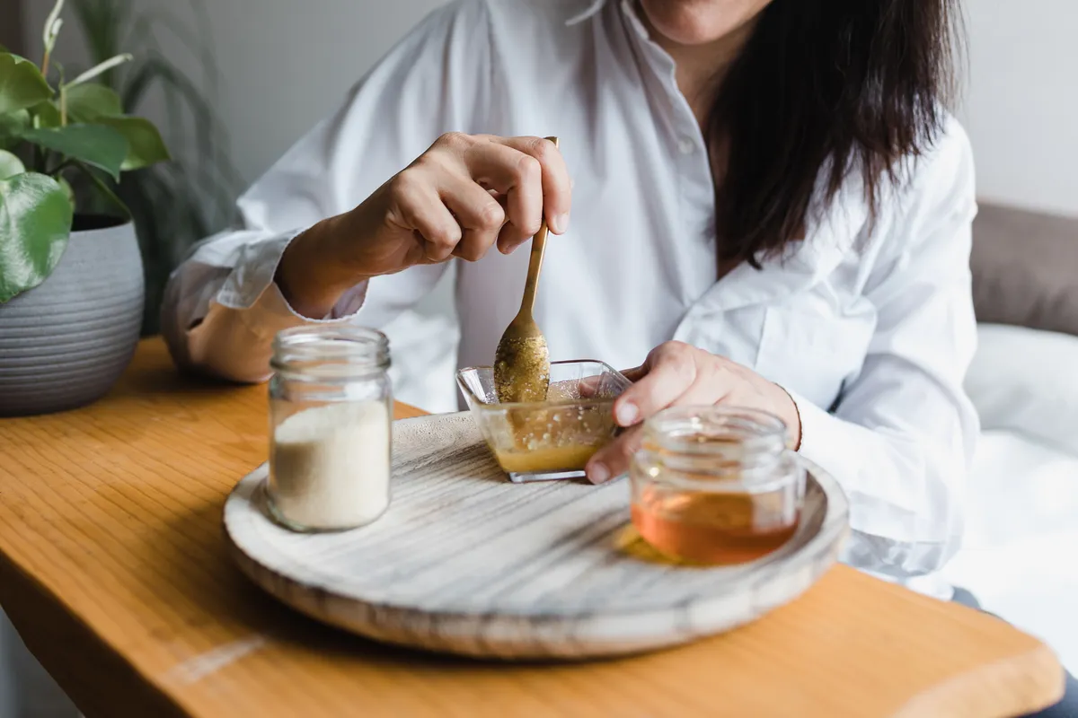 Mézes arcpakolást készítő nő