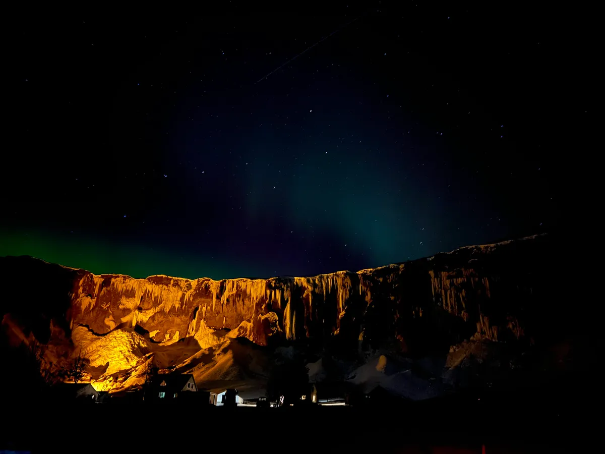 Éjszakai kivilágítás egy fagyott vízesésnél Izlandon.