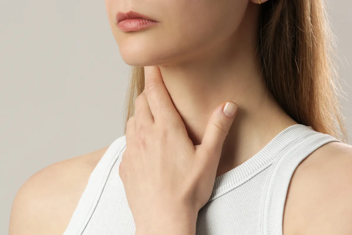 Torokfájással küzdő fiatal nő