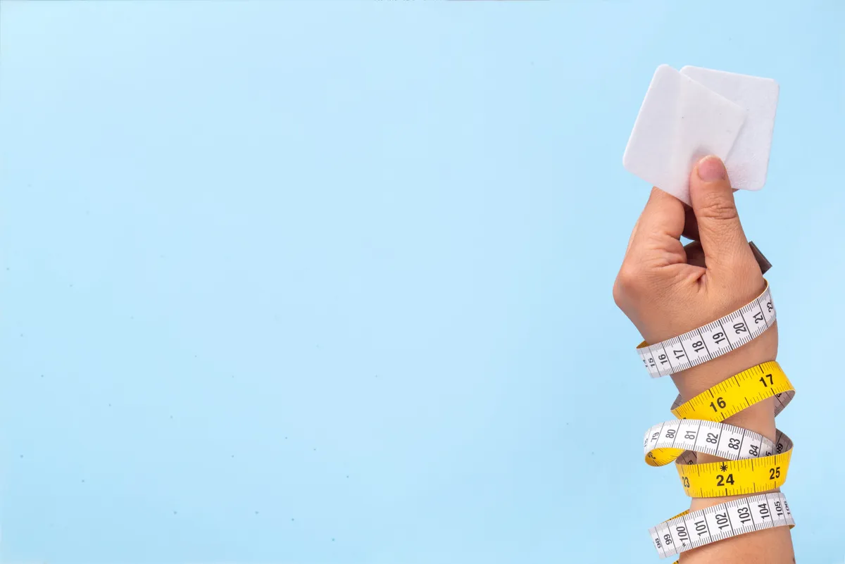 Fogyókúrás tapaszt tartó kéz.