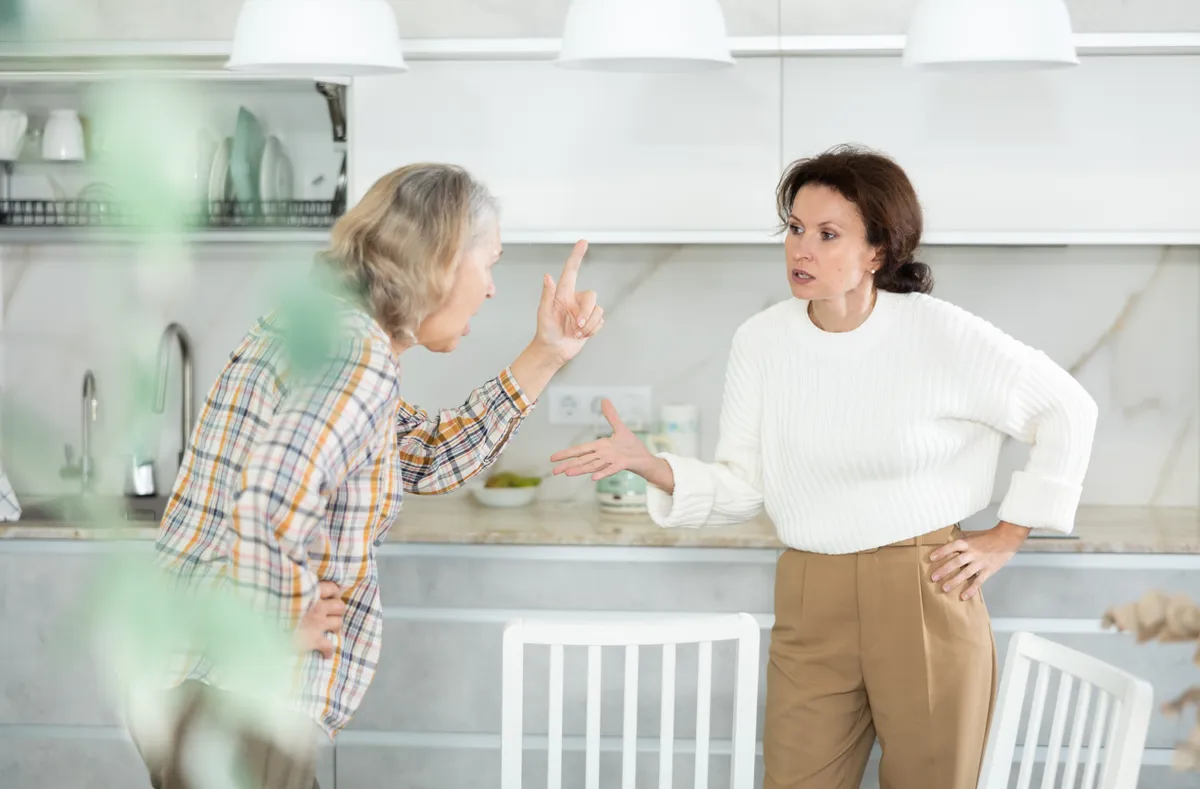 Angry old and middle-aged women quarreling aggressively to each other in the kitchen