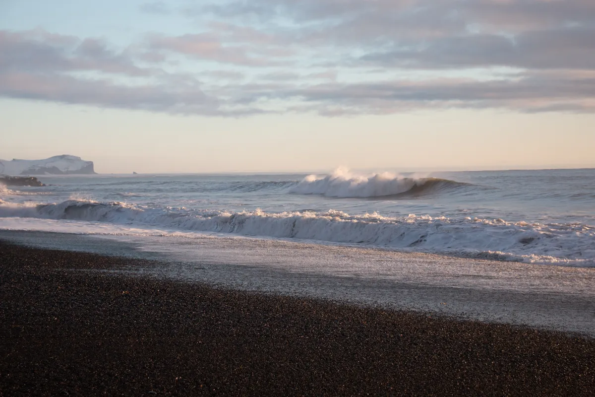 Izlandi tengerpart télen sötét homokkal.