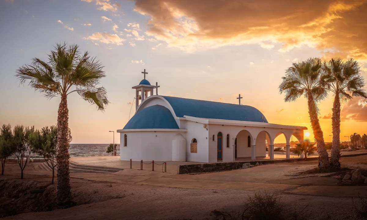 A ciprusi Aya Napa tengerpartja naplemente idején kápolnával.