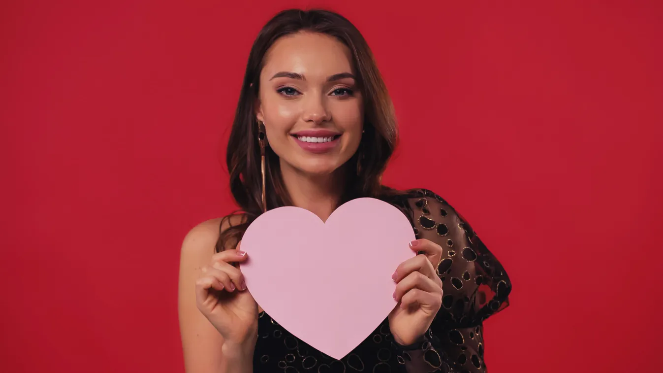 Fiatal nő szívet tart a kezében a Valentin-napi verskvízben