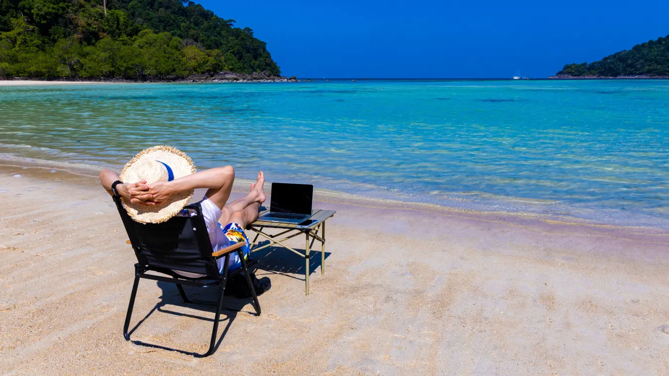 A külföldi bevételei után szja-mentességet élvező digitális nomád a tengerparton laptoppal