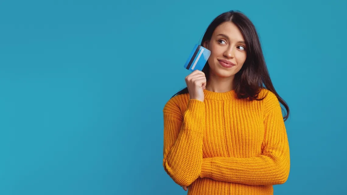 Thoughtful,Young,Girl,Wearing,Yellow,Clothes,Holding,Plastic,Credit,Card