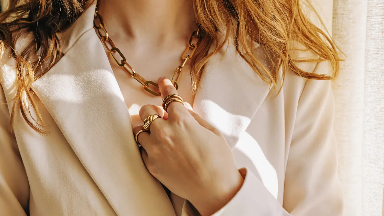 Arany ékszereket viselő elegáns nő.