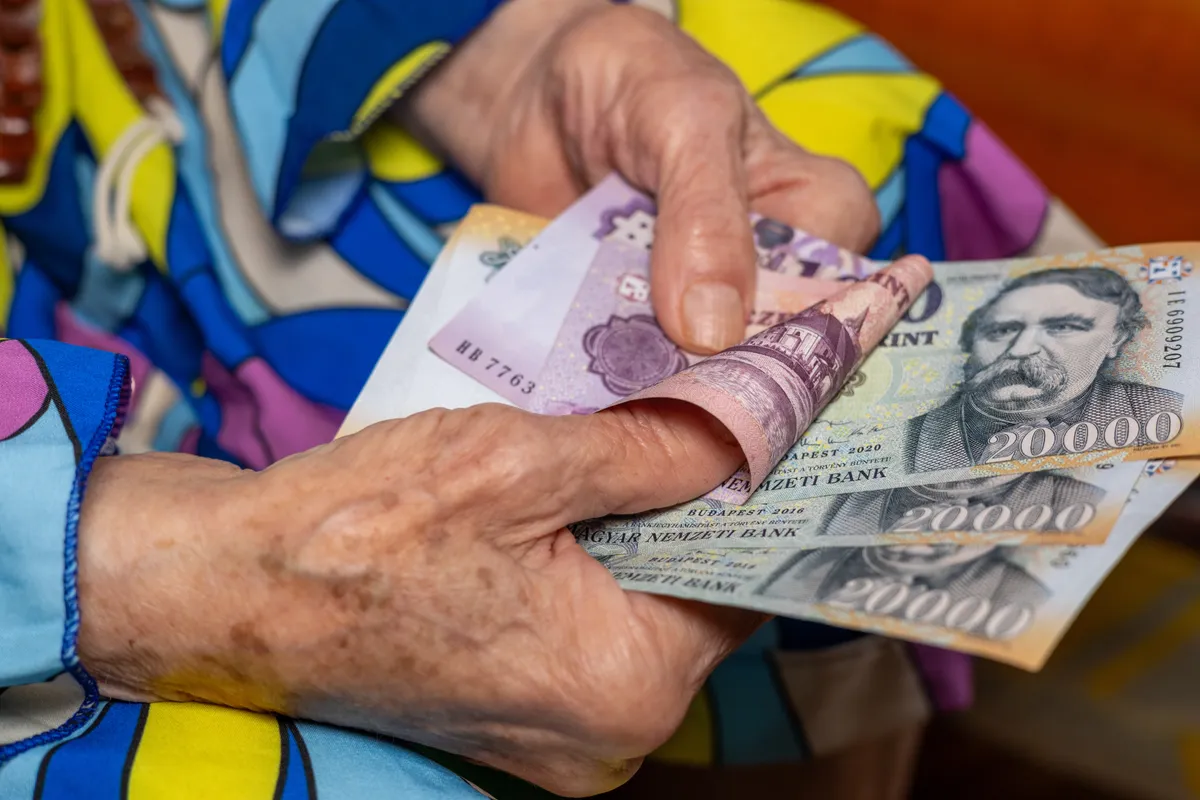 nyugdíjas nő kezében magyar pénzekkel.