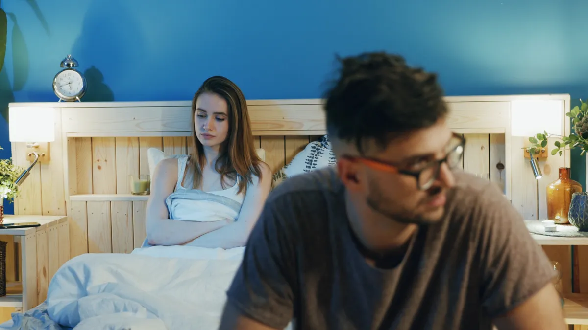 Szomorú nő fekszik az ágyban együttlét után.