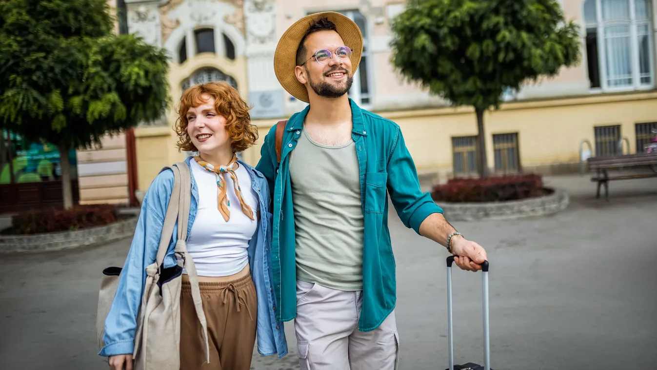 Télből tavaszba utazó boldog fiatal pár sétája egy mediterrán város parkjában