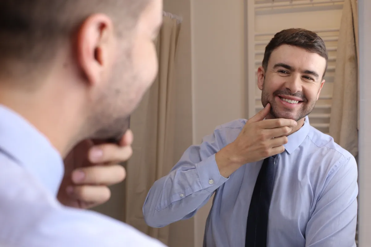 Nárcisztikus férfi elégedetten nézi magát a tükörben.