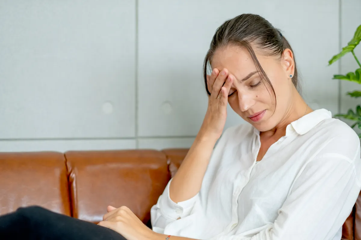 Mentális fáradtsággal küzdő nő egy kanapén