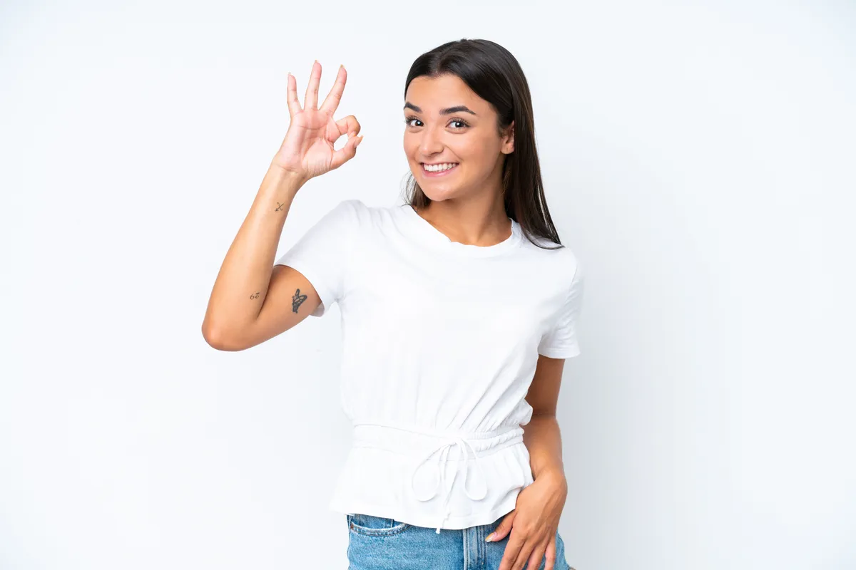 Ovális arcformával rendelkező nő mosolyogva oké jelet mutat