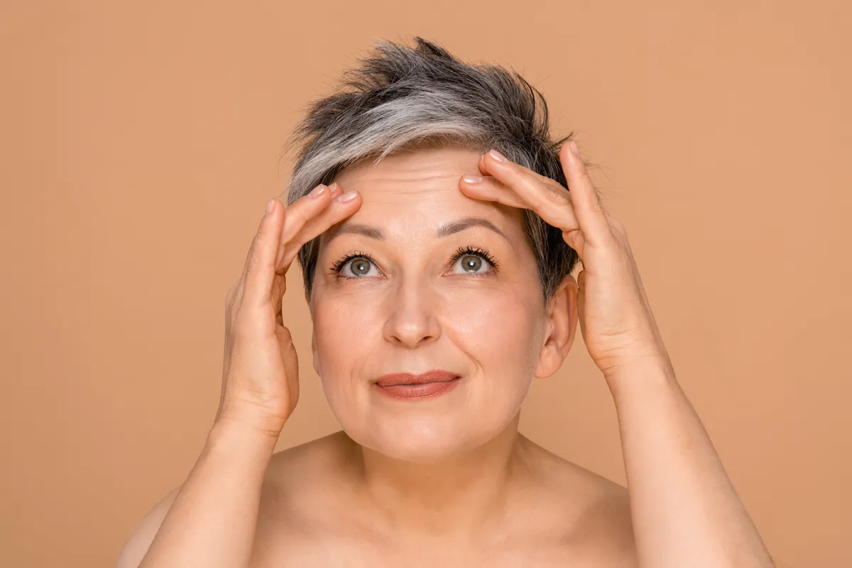 A személyiségteszt miatt a homlokát nézegető középkorú nő.