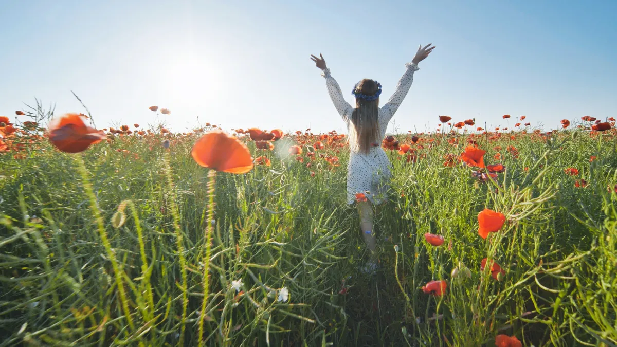Öreg lélekkel rendelkező fiatal nő egy pipacsmezőn