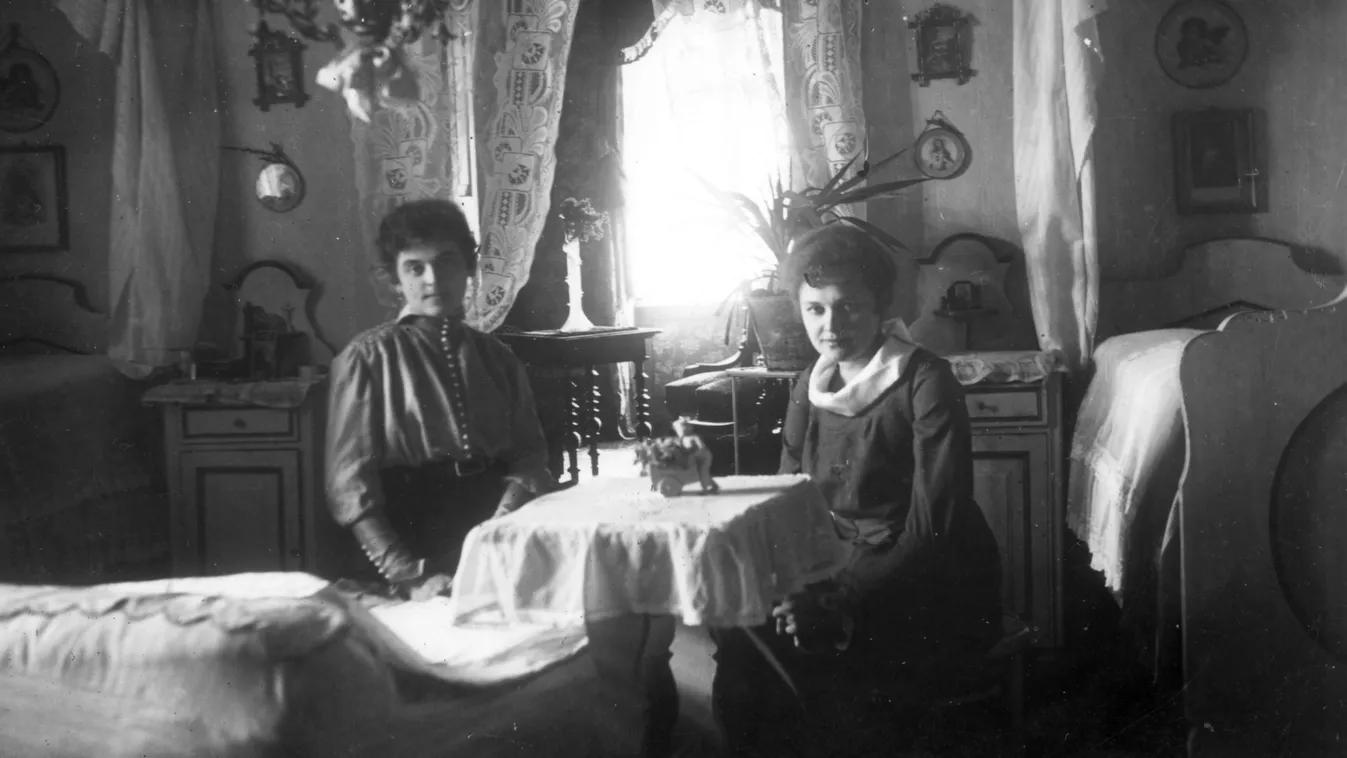 Retró kvízben szereplő fekete-fehér kép régi bútornál ülő nőkről egy szobában