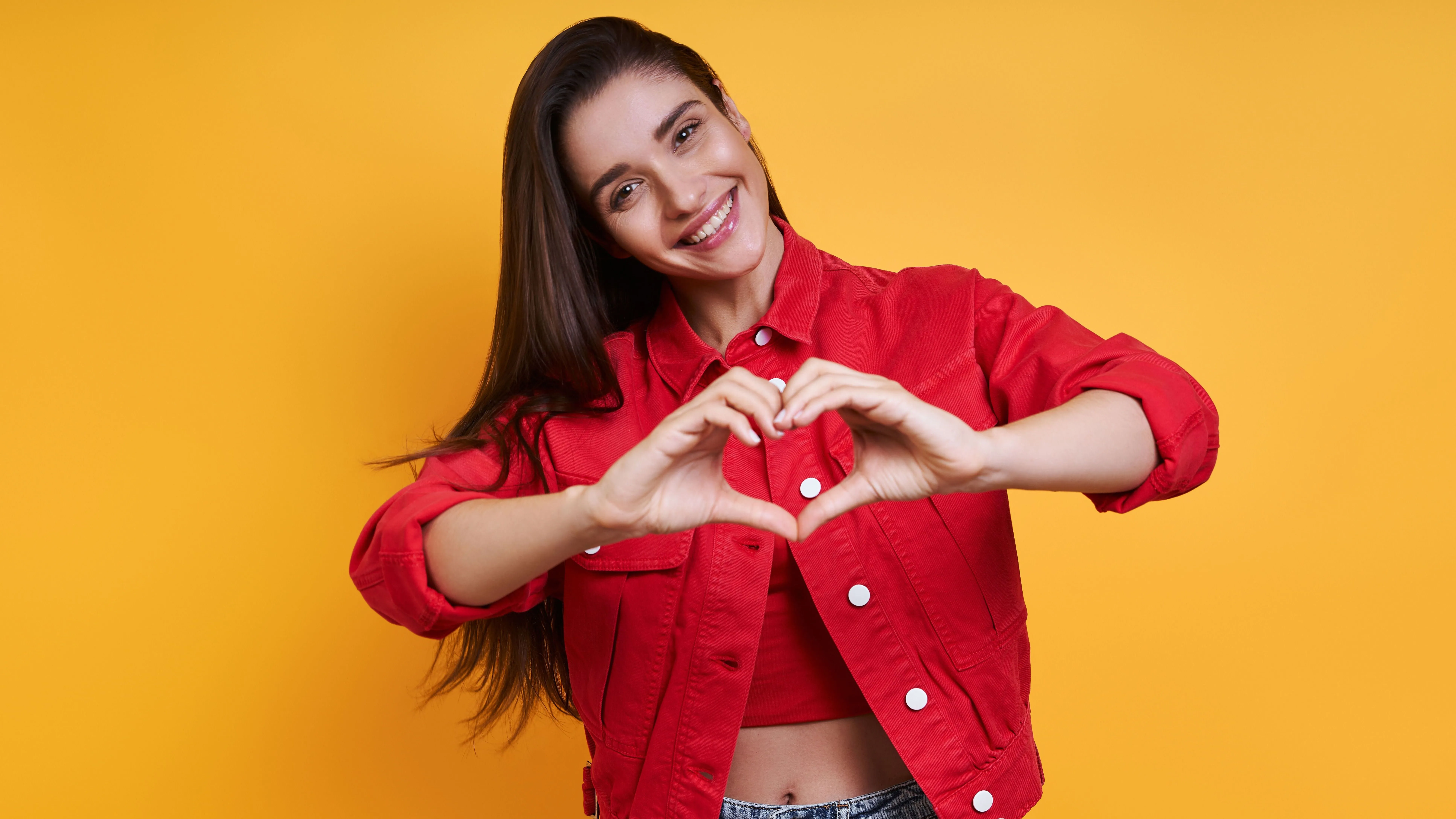 Body literacy miatt a testében önmagát kiválóan érző fiatal nő a kezével szív alakot formázva