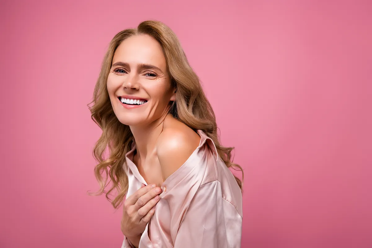 Kamerába mosolyó nő, akinek fontos a fiatalság megőrzése.