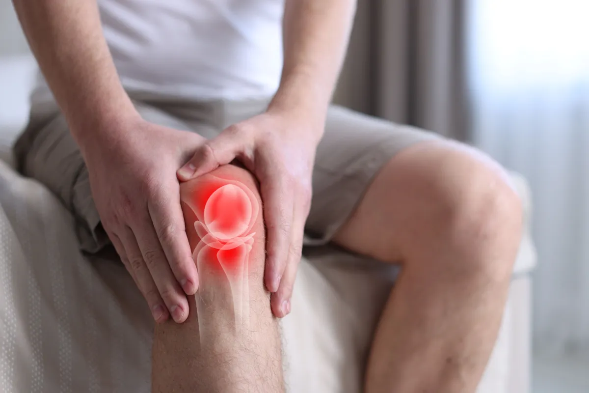 Férfi ízületi fájdalommal küzd melegfront idején.