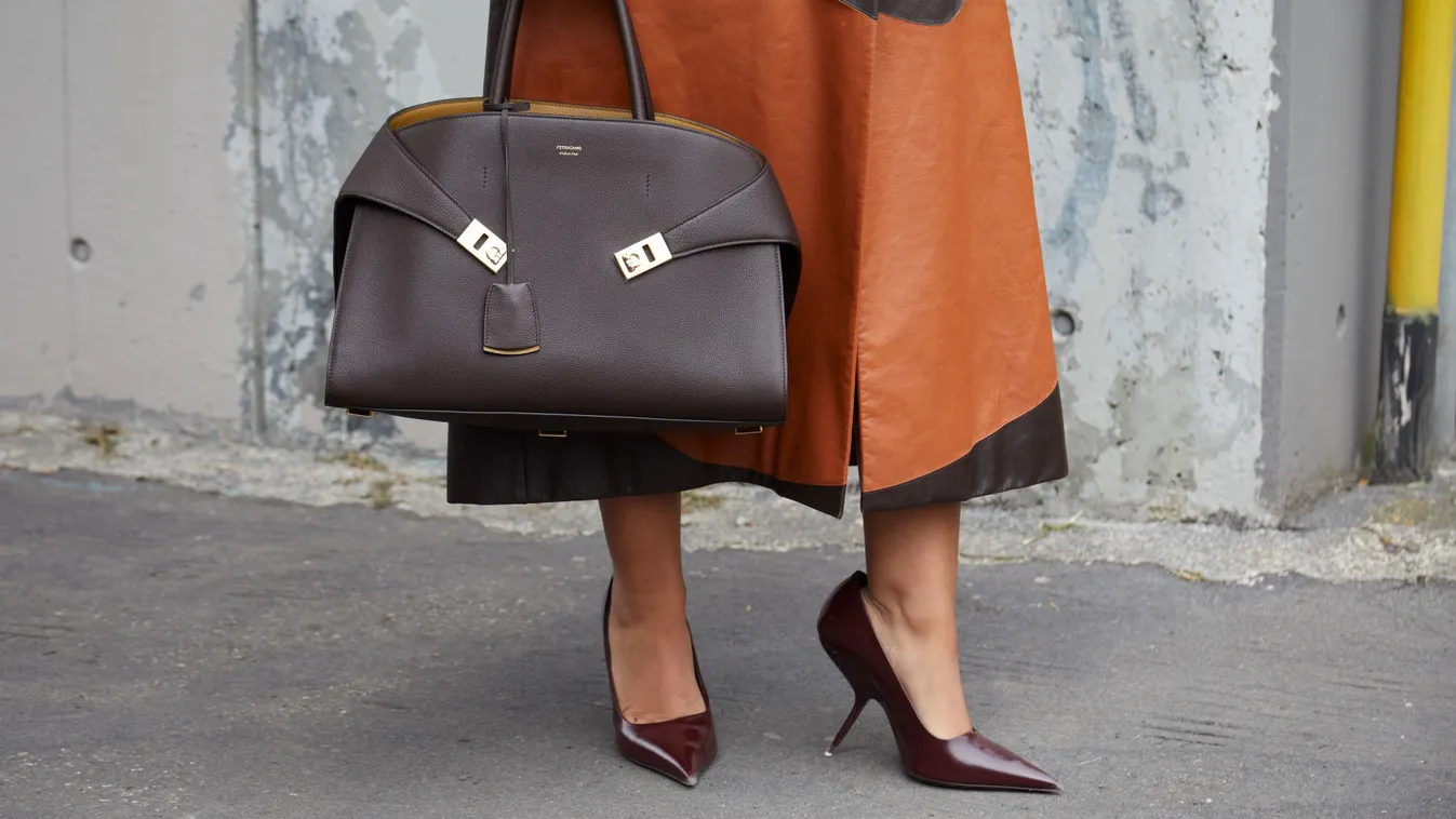 Divatos középkorú nő nagy táskával a kezében.