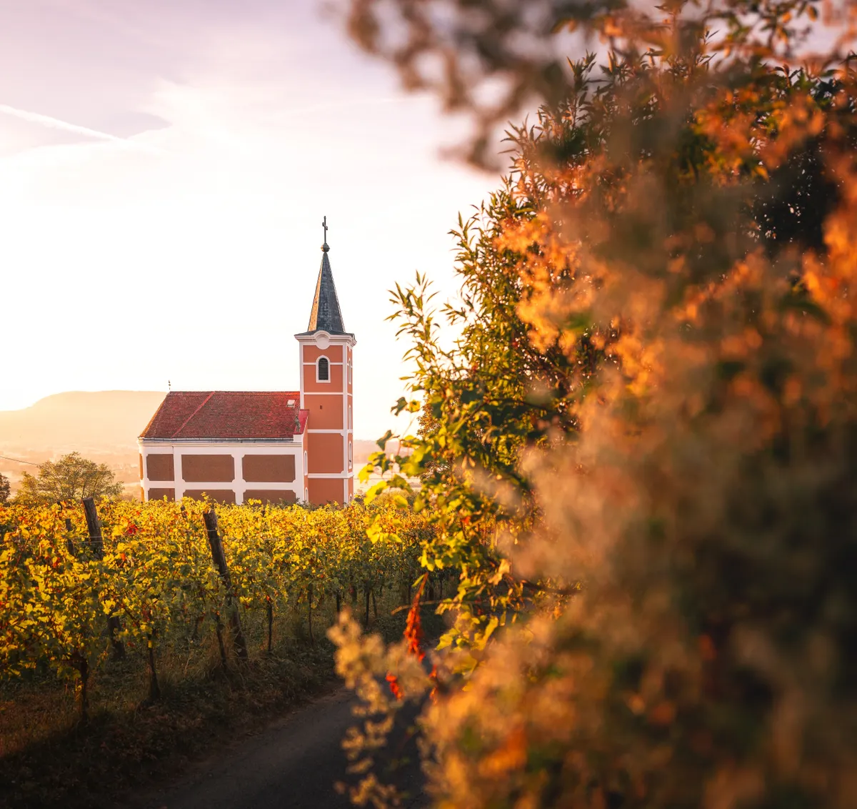 A hegyagasi Lengyel-kápolna nyári, ősz eleji környezetben, arany fényekkel. 