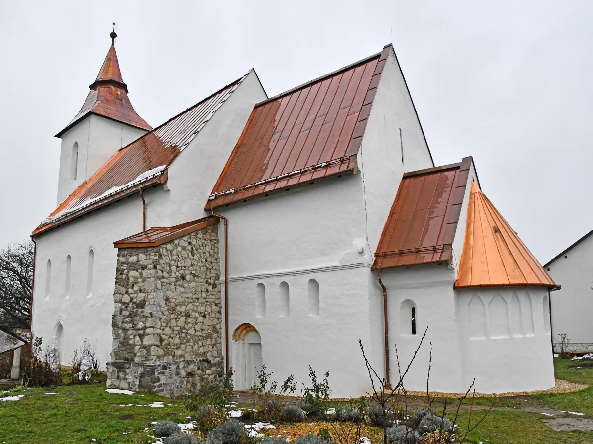 A vizsolyi református templom kívülről egy téli napon olvadó hóval.