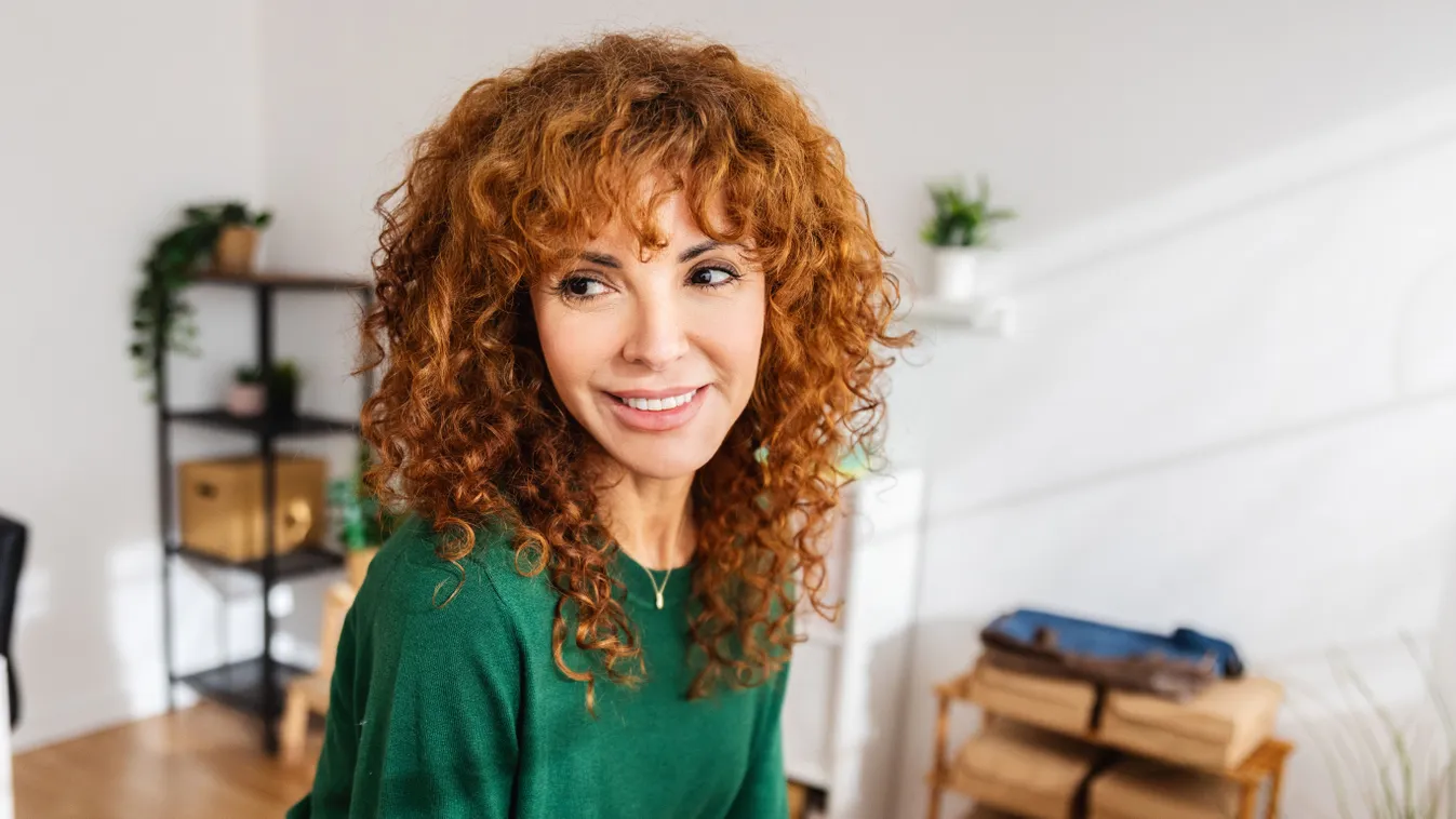 Vörös hajú nő hozzá passzoló zöld pulóverben.