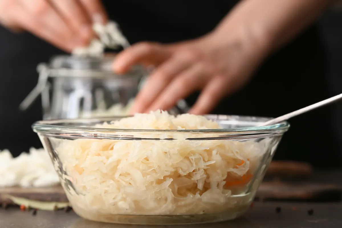 Házi savanyú káposzta receptet készítő nő.