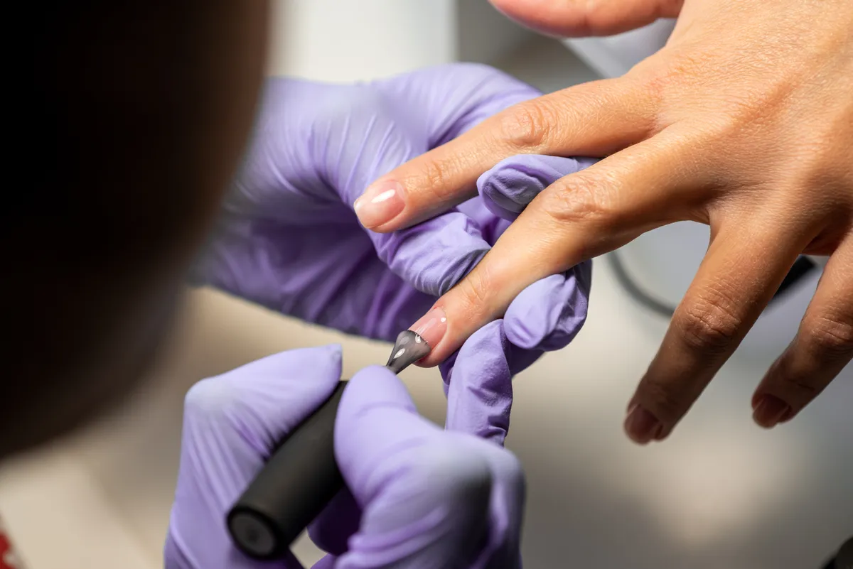 Műkörmös manikűrt készít egy nőnek.