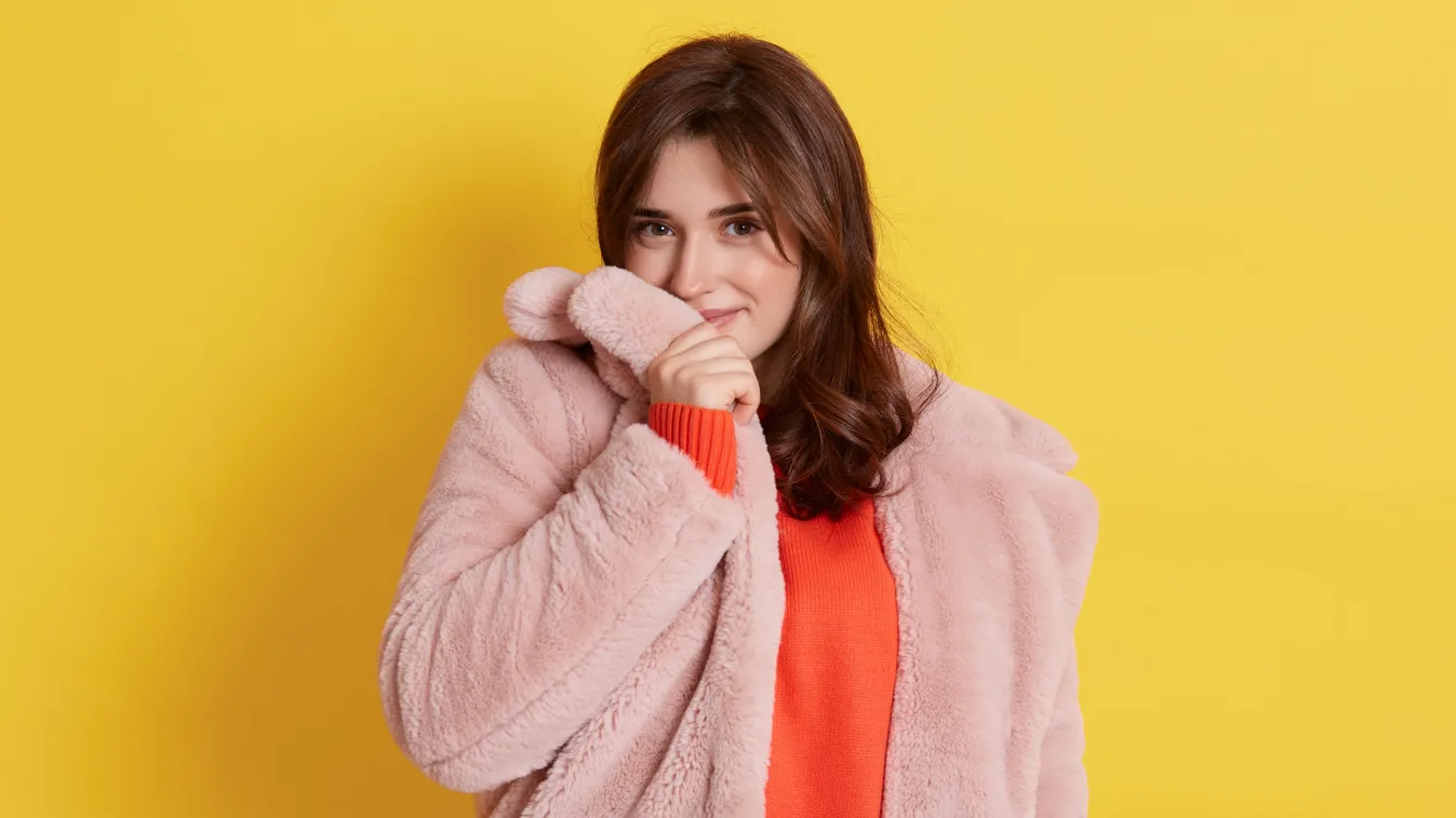 Télikabátját a szájához emelő nő az anyagon sminkfoltot okozva