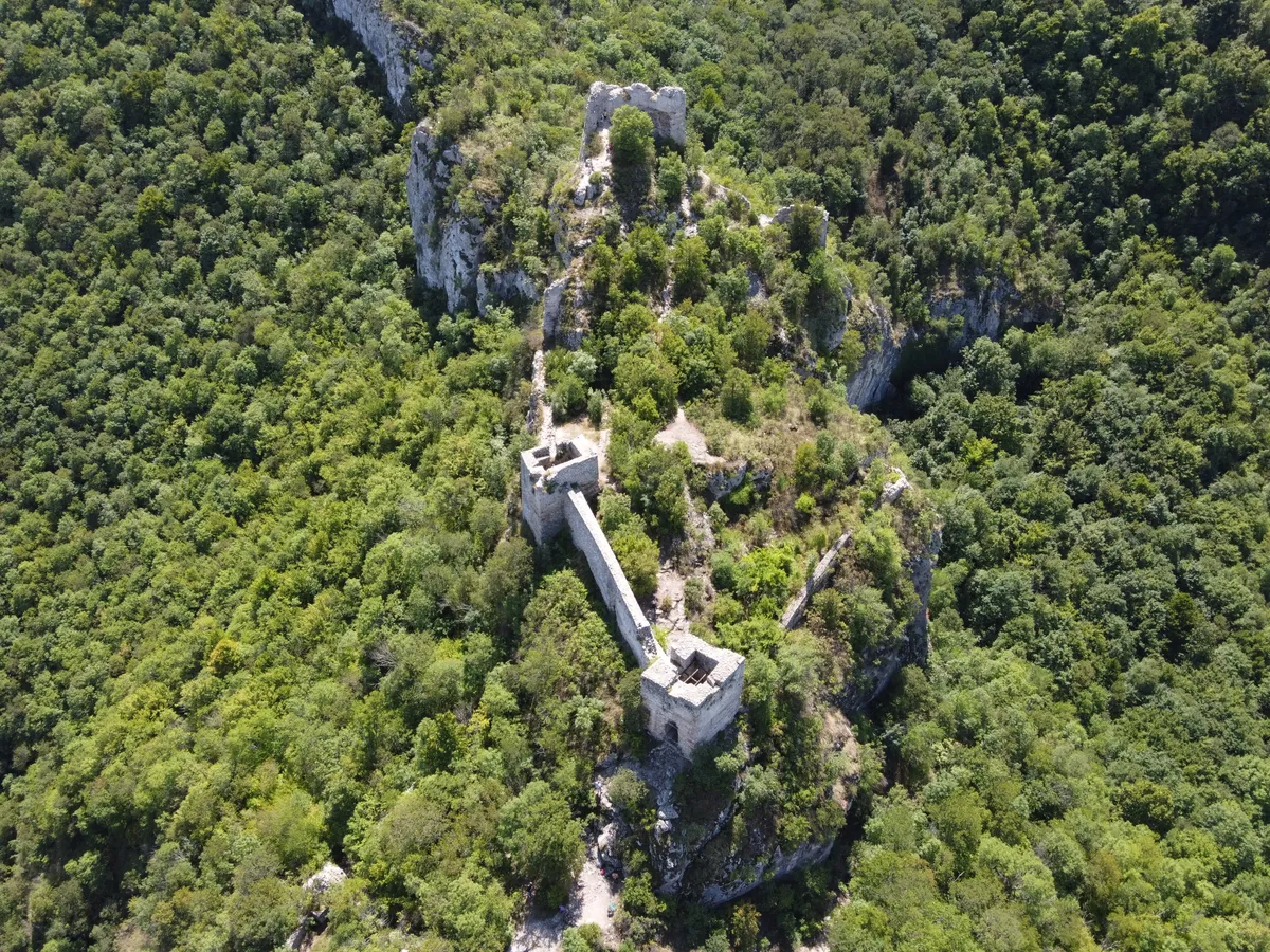 Az erdővel körülvett Soko Grad, Sokobanja romos erődítménye a magasból fotózva.