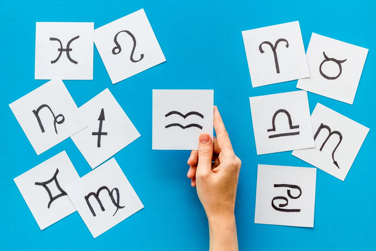 A horoszkóp csillagjegyeinek jele egy papírlapokon.