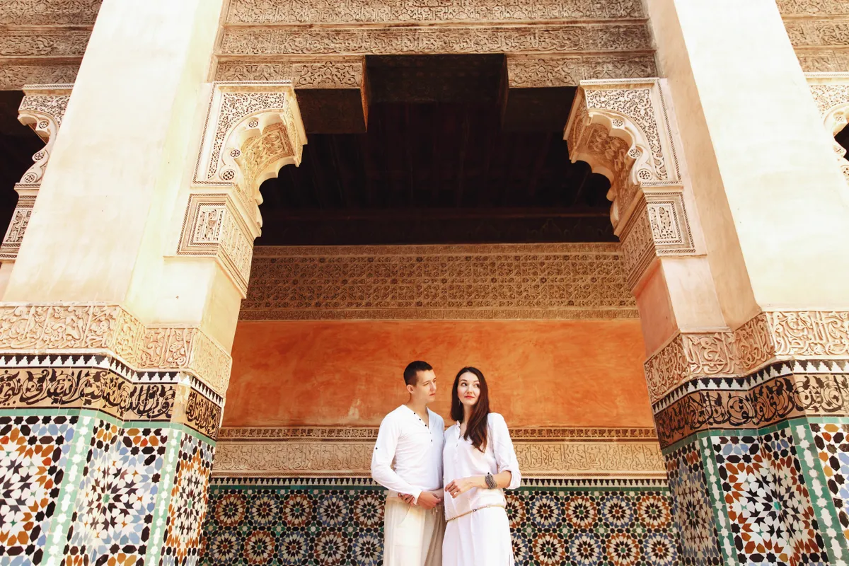 Marrakesh díszes épületei között összebújó szerelmespár.