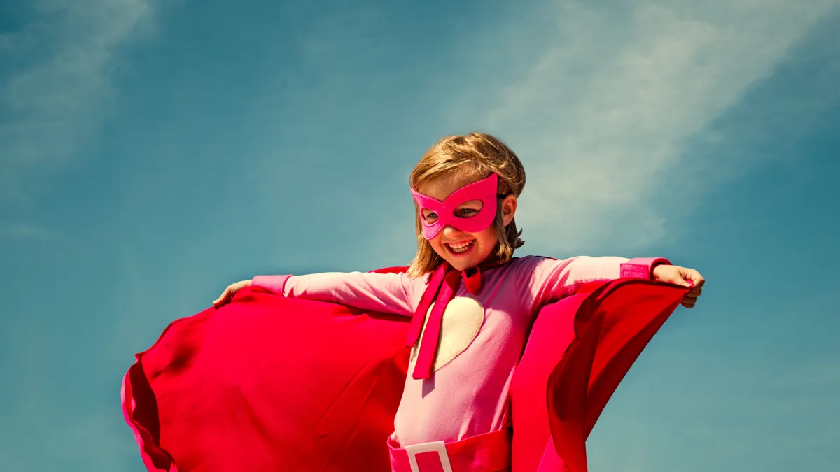 Személyiségtesztben szereplő kép egy piros szuperhős ruhába öltözött kislányról