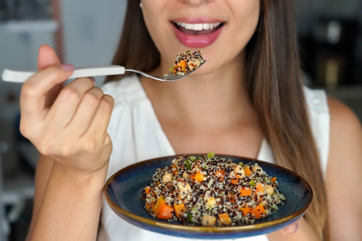 Fiatal nő quinoát eszik a puffadás ellen.