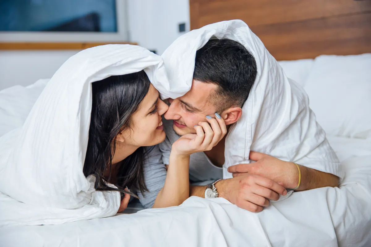 Szerelmespár fekszik az ágyban együttlét után.