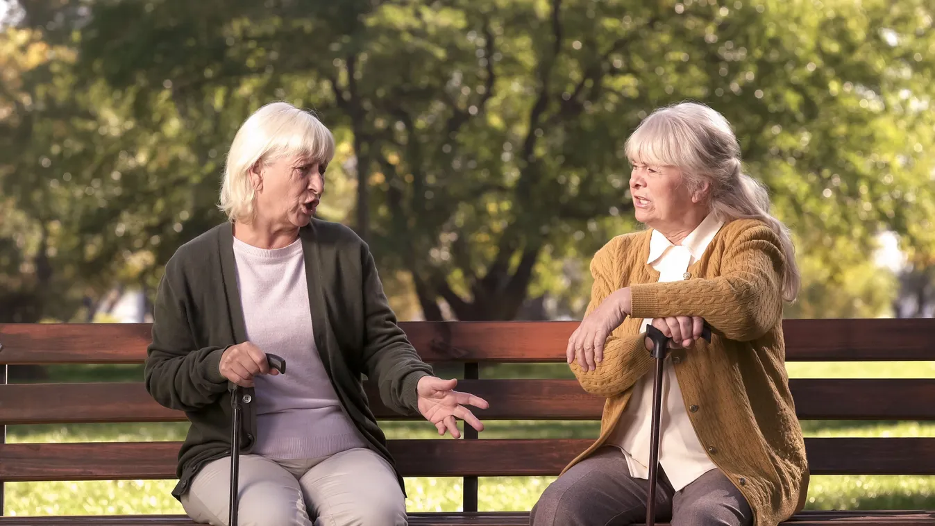 Nagyszülők rivalizálása a parkban egy padon.