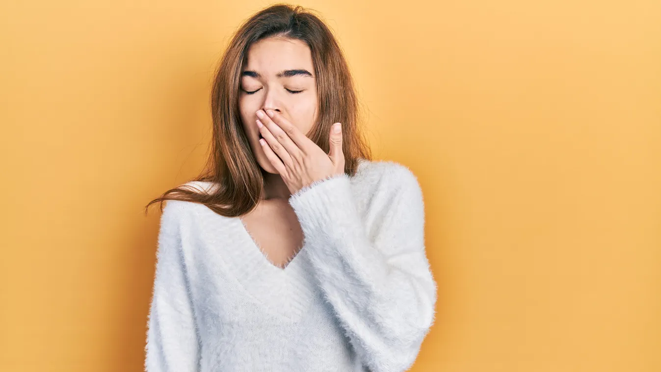 Ásító nő, aki nem tudja, miért ásítunk valójában