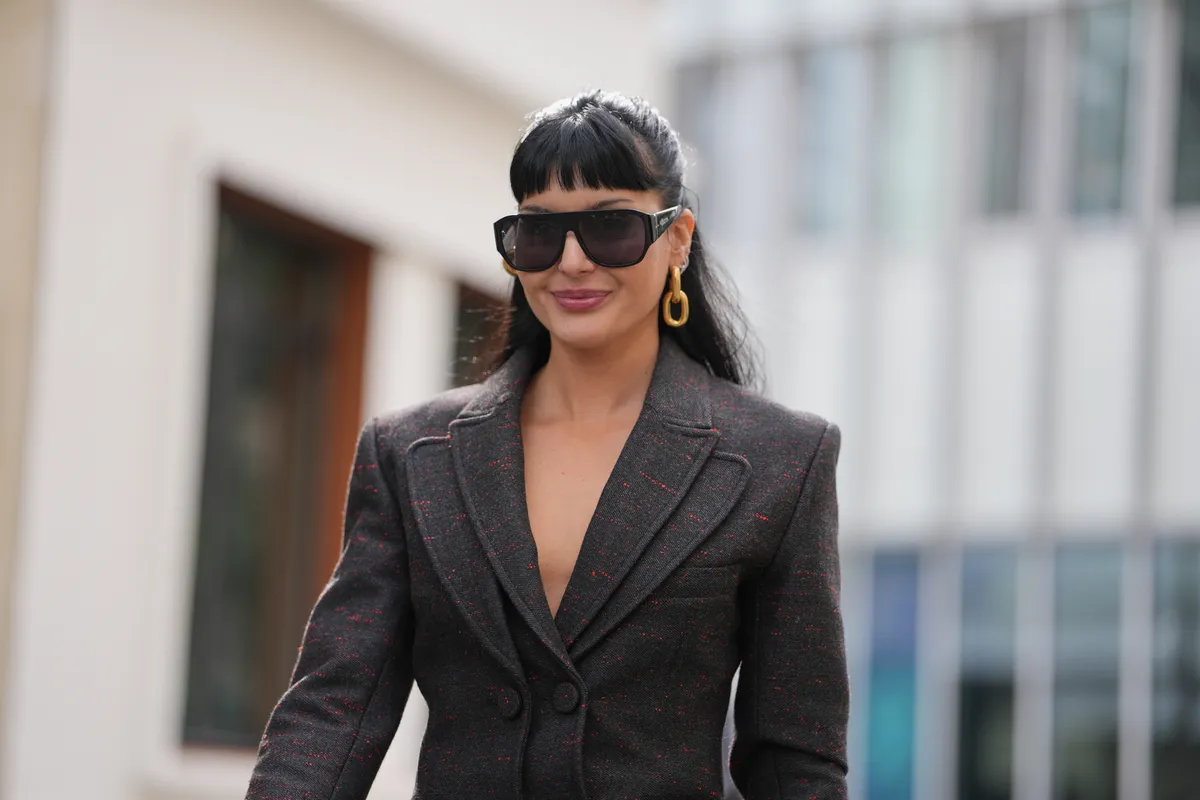 Fekete hajú nő divatos szettben az utcán.