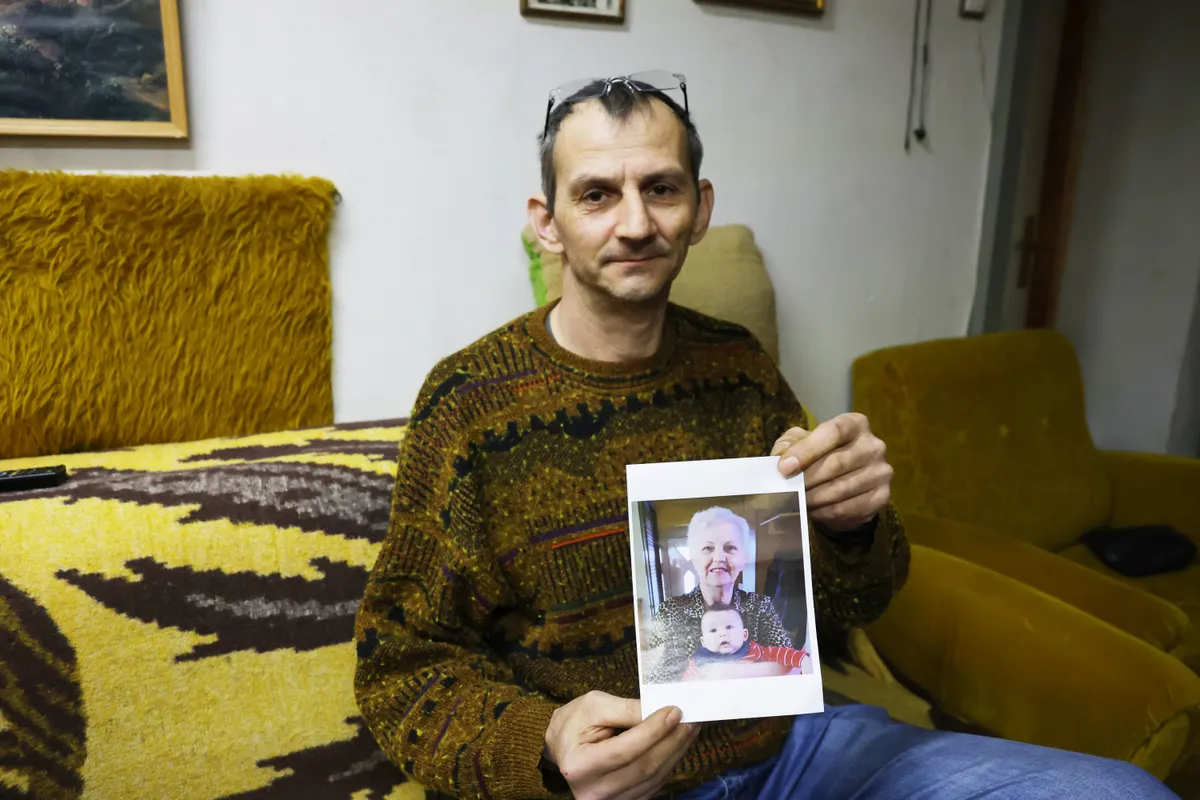 A győri gázolás áldozatának fia, János, kezében Ilona néni fényképével