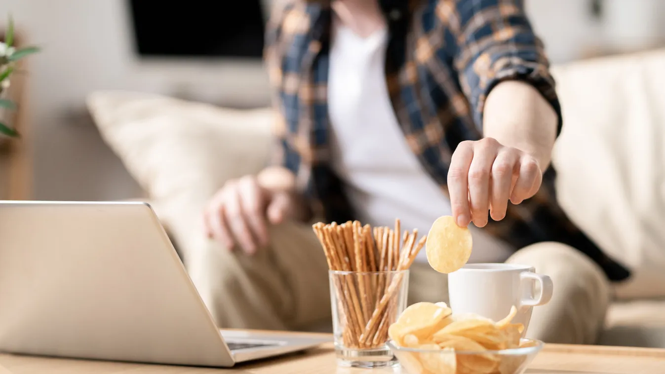 Nassoló férfi, aki a személyiségteszt alapján csipszet nassol.