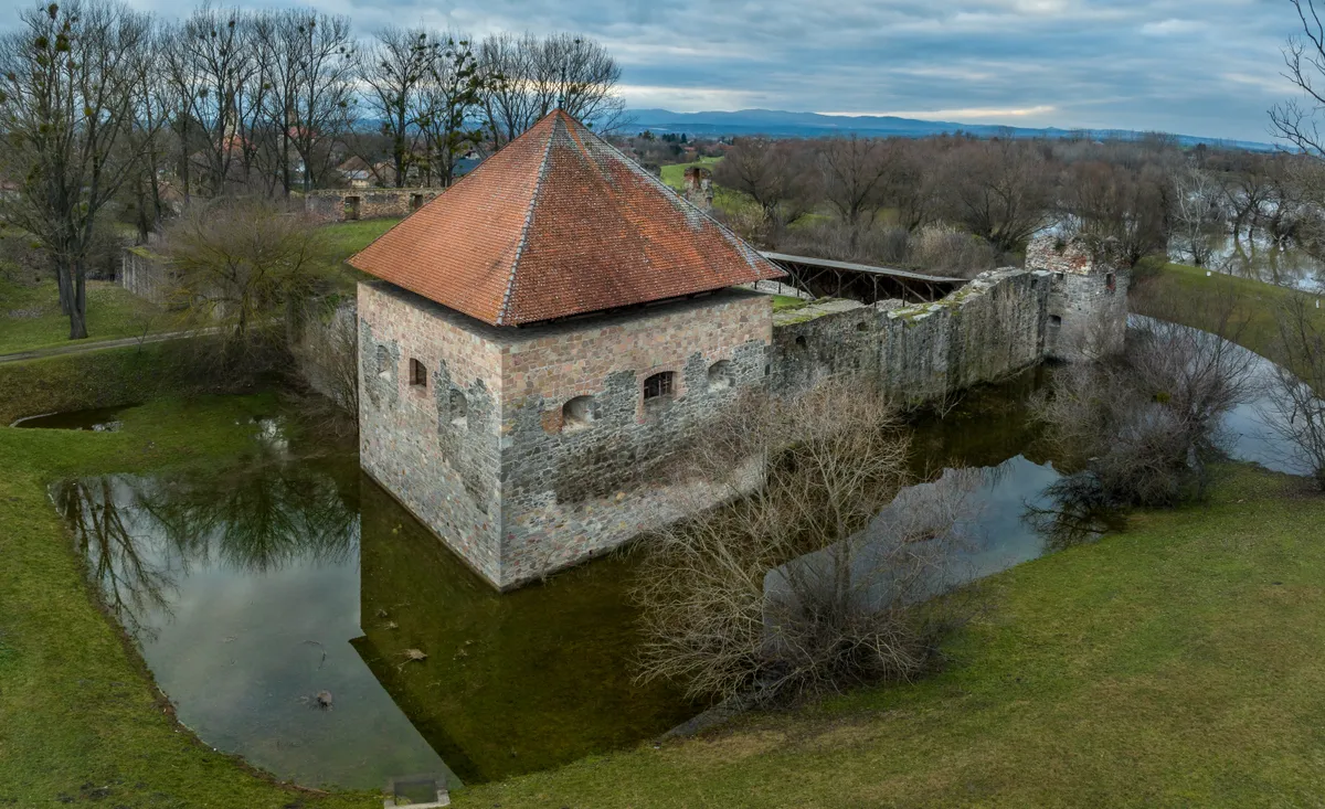 Az ónodi vár délkeleti, helyreállított bástyája és a várat körülvevő vizes árok téli, kora tavaszi időszakban.