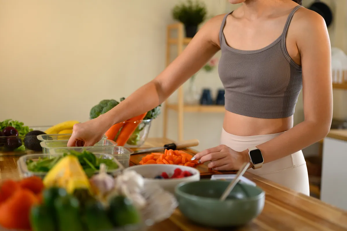 Zöldségeket előkészítő nő, aki egészséges diétát követ.