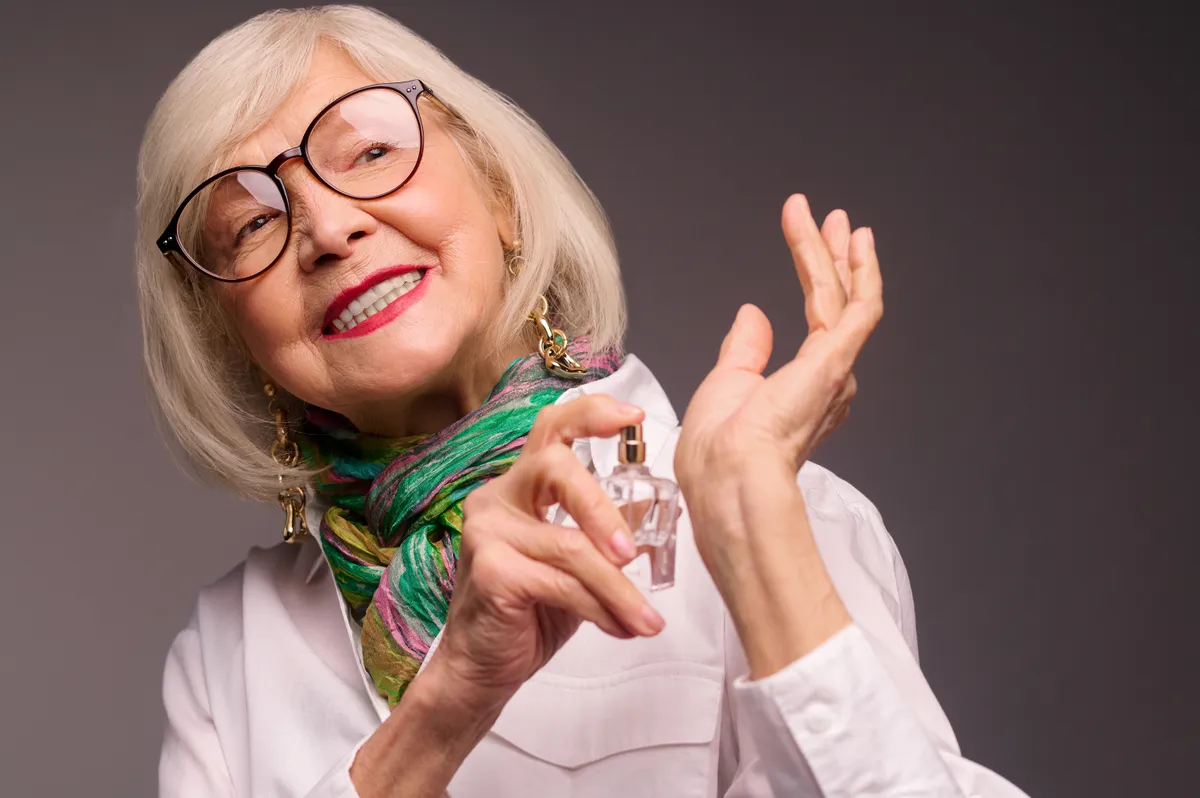 Magát parfümöző középkorú nő.