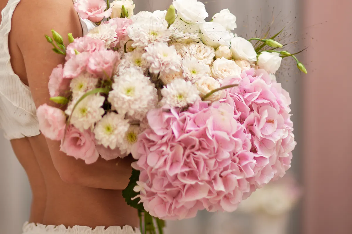 Hortenzia Valentin-napi virágcsokrot tartó nő.