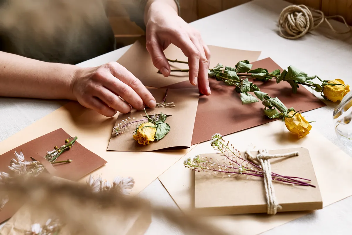 Díszítésként szárított virágokat tűzdelő nő