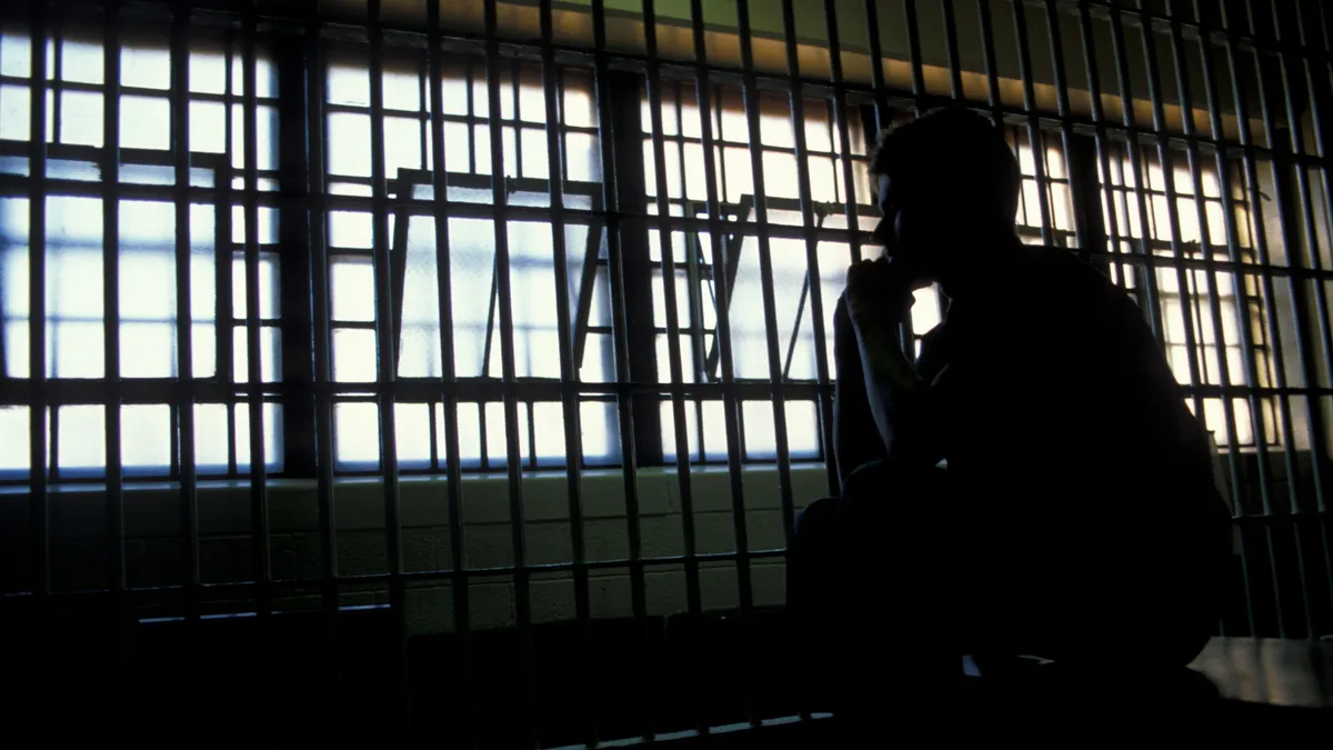 Silhouette,Of,An,Adult,Male,In,A,Jail,Cell.,Created
