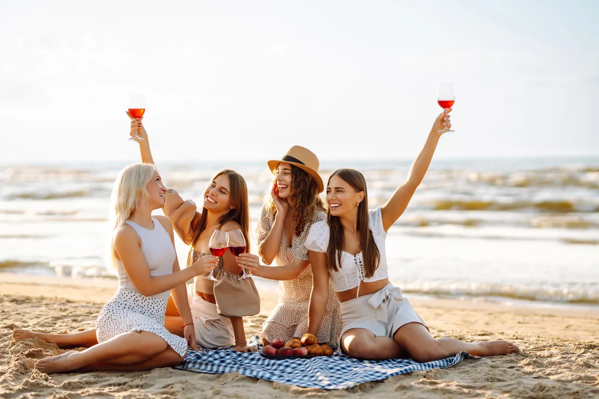 A horvátországi város, Split strandján itallal koccintó nők. 